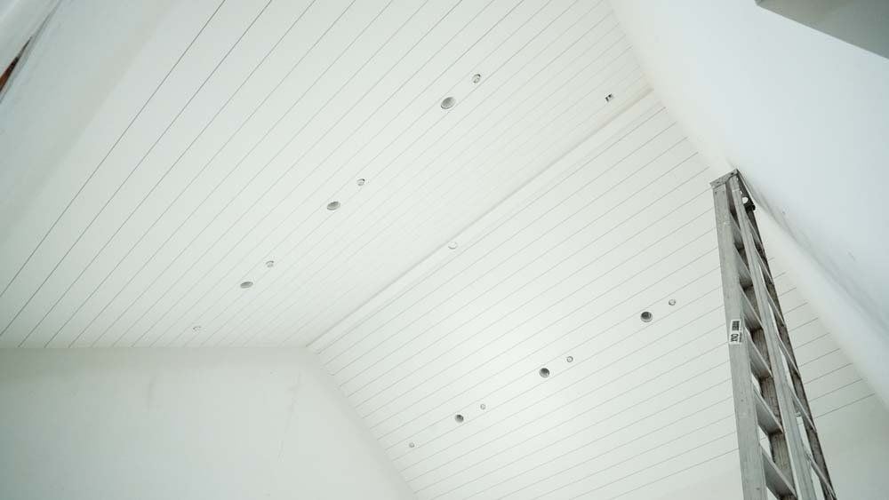 Looking up at a white ceiling with a ladder in the foreground.