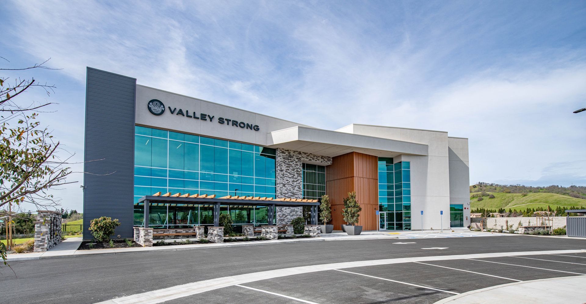 A large building with a lot of windows and a parking lot in front of it.