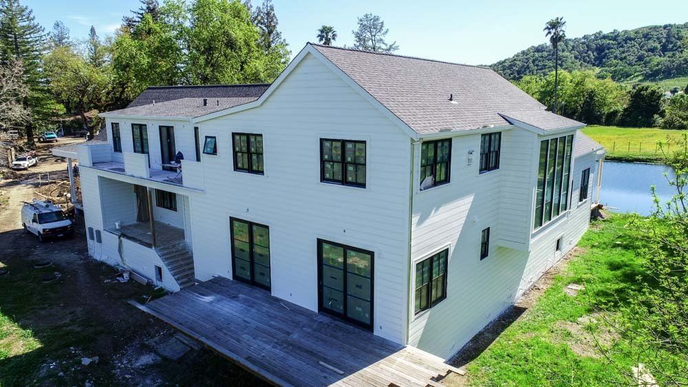 An aerial view of a large white house in the middle of a field.