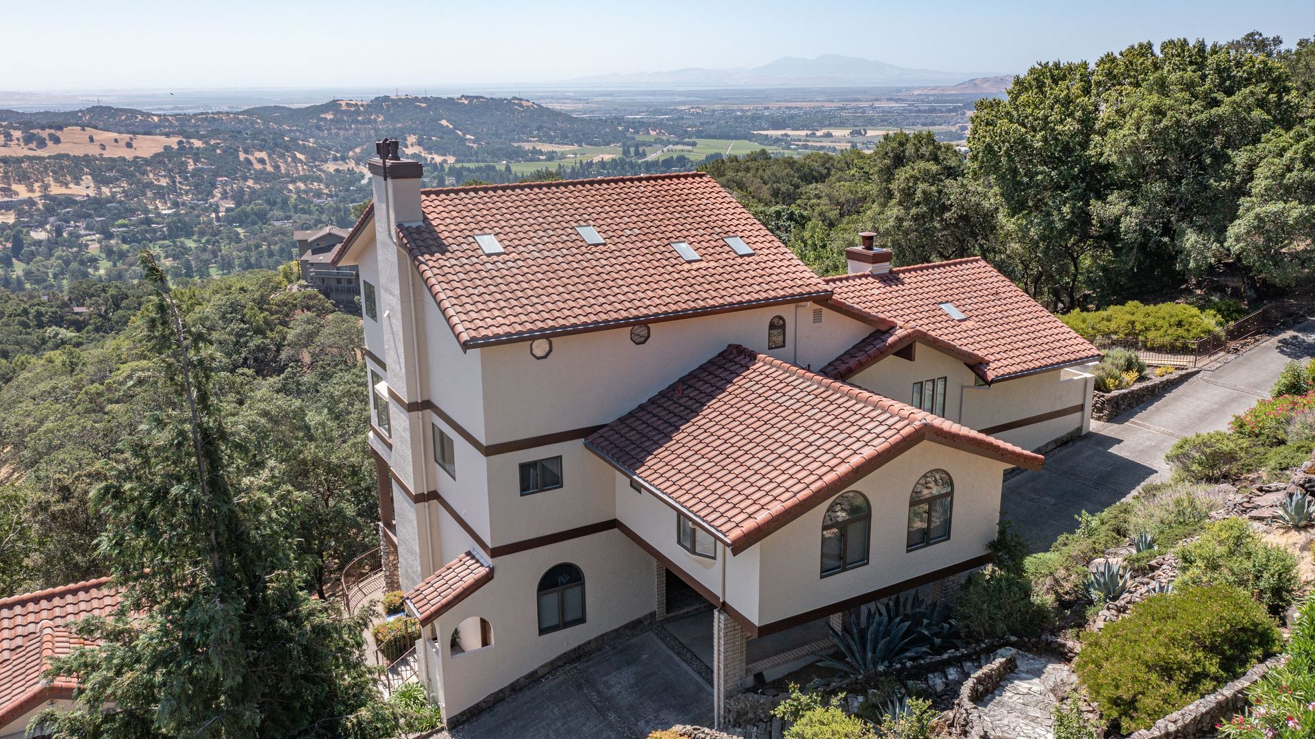 An aerial view of a large house with a red tile roof