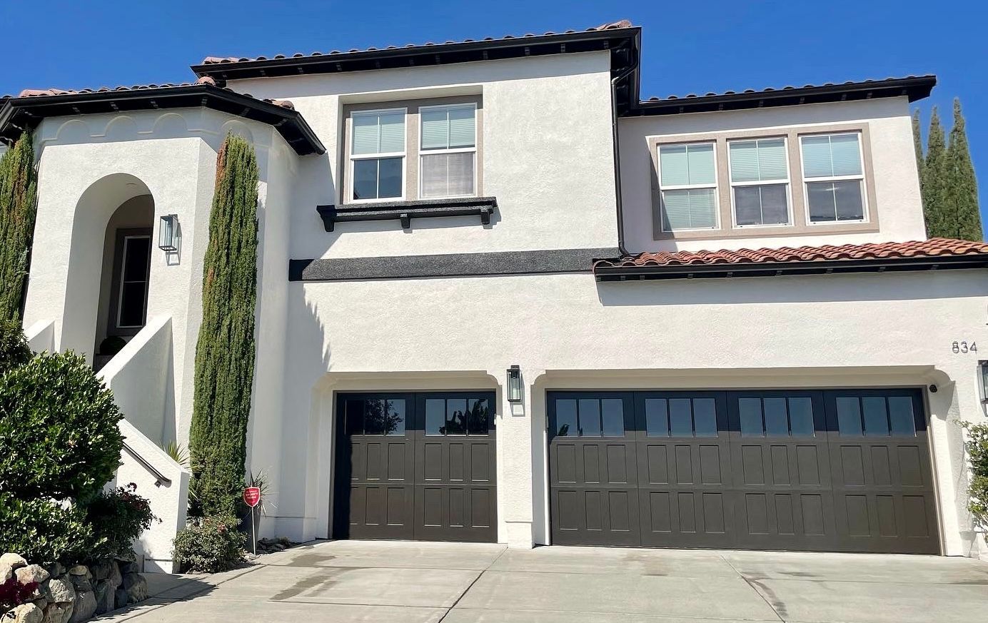 A large white house with two garage doors and stairs