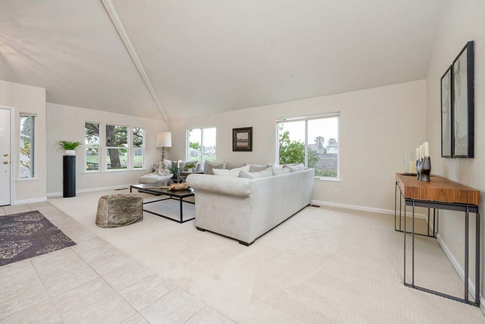 A living room with a white couch and a wooden table.
