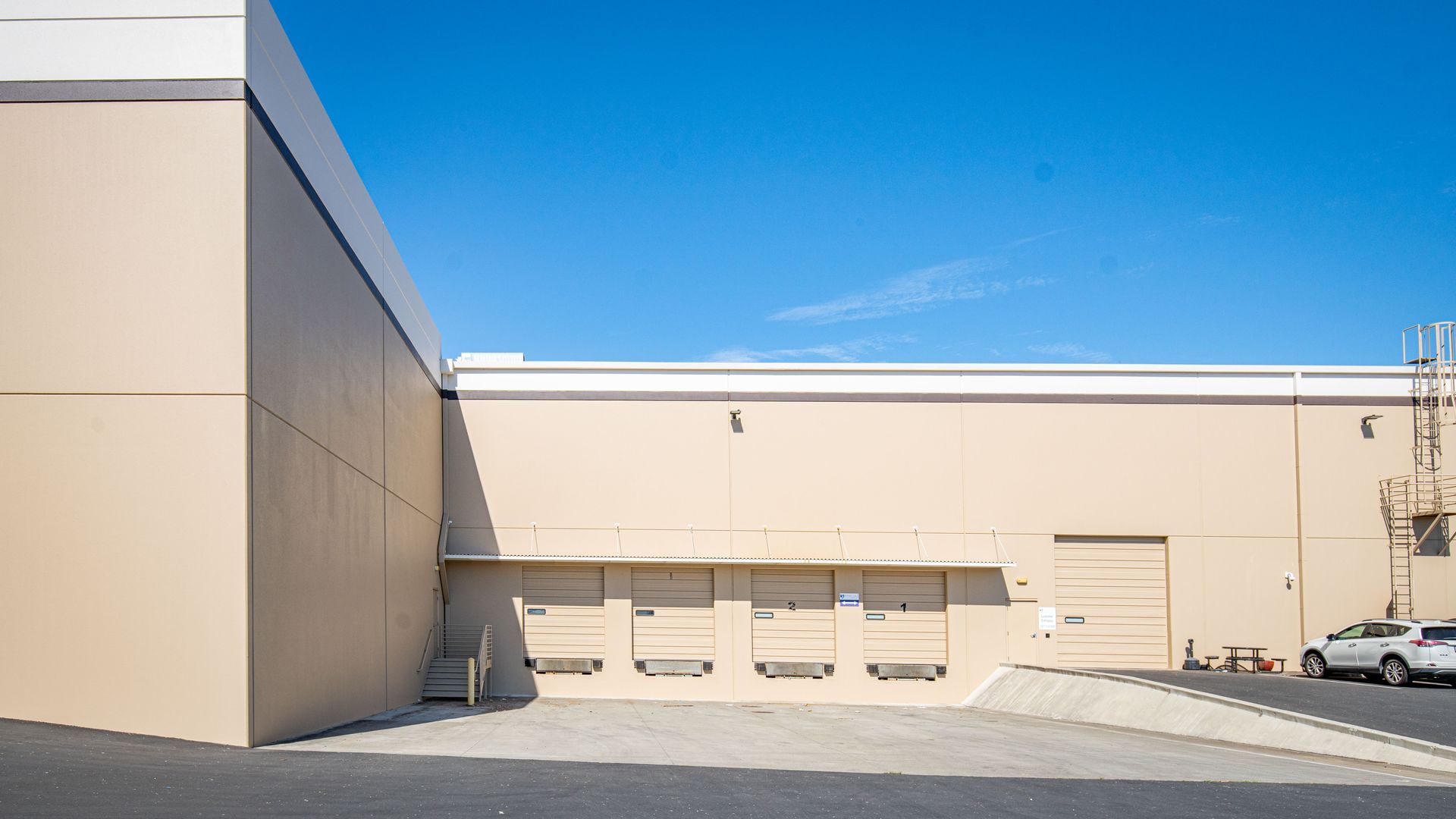 A large building with a lot of doors and a car parked in front of it.
