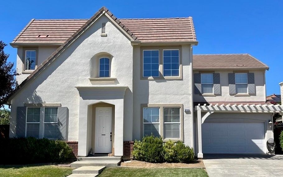 A white house with a brown roof and a white door