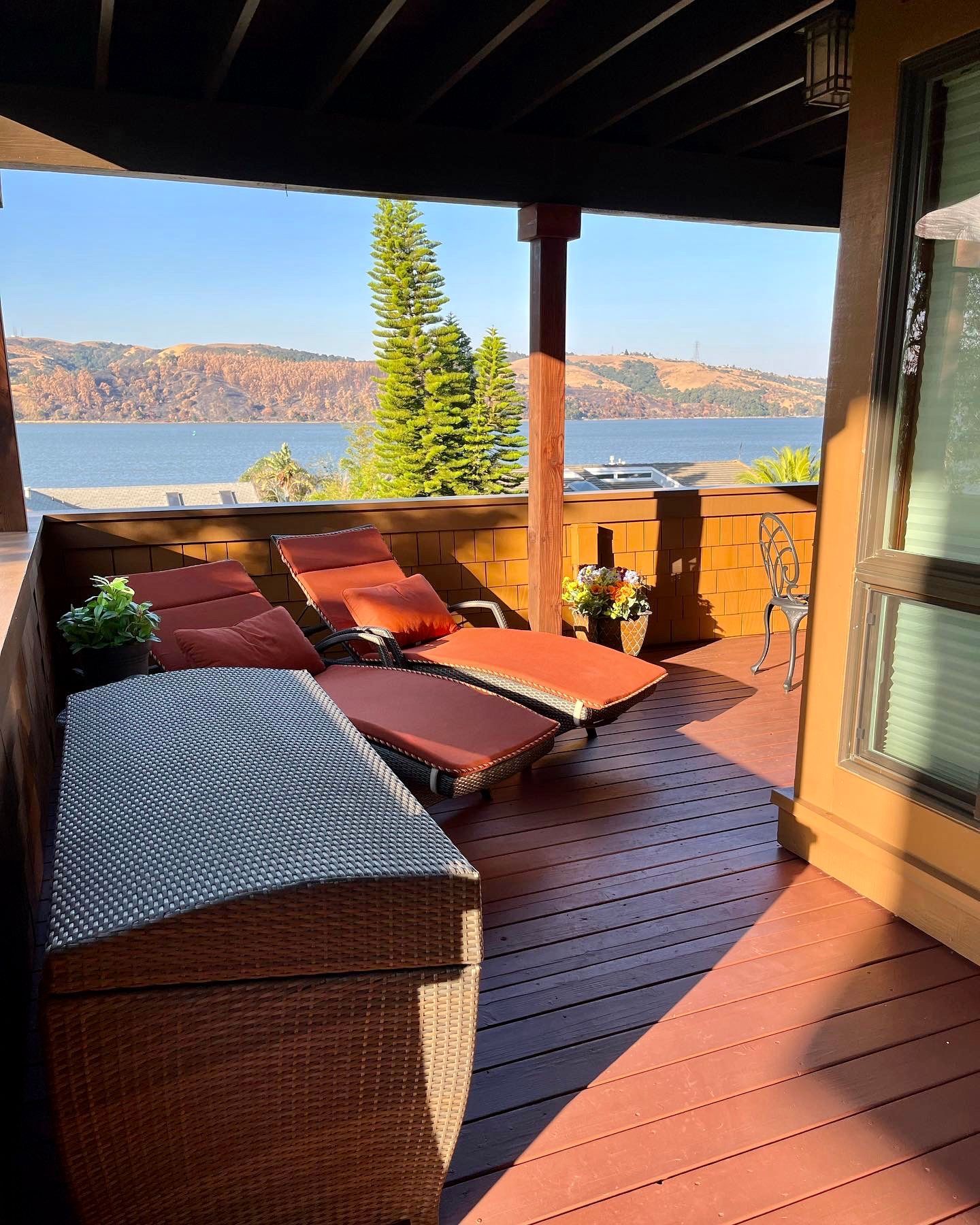 A deck with a view of a lake and mountains.