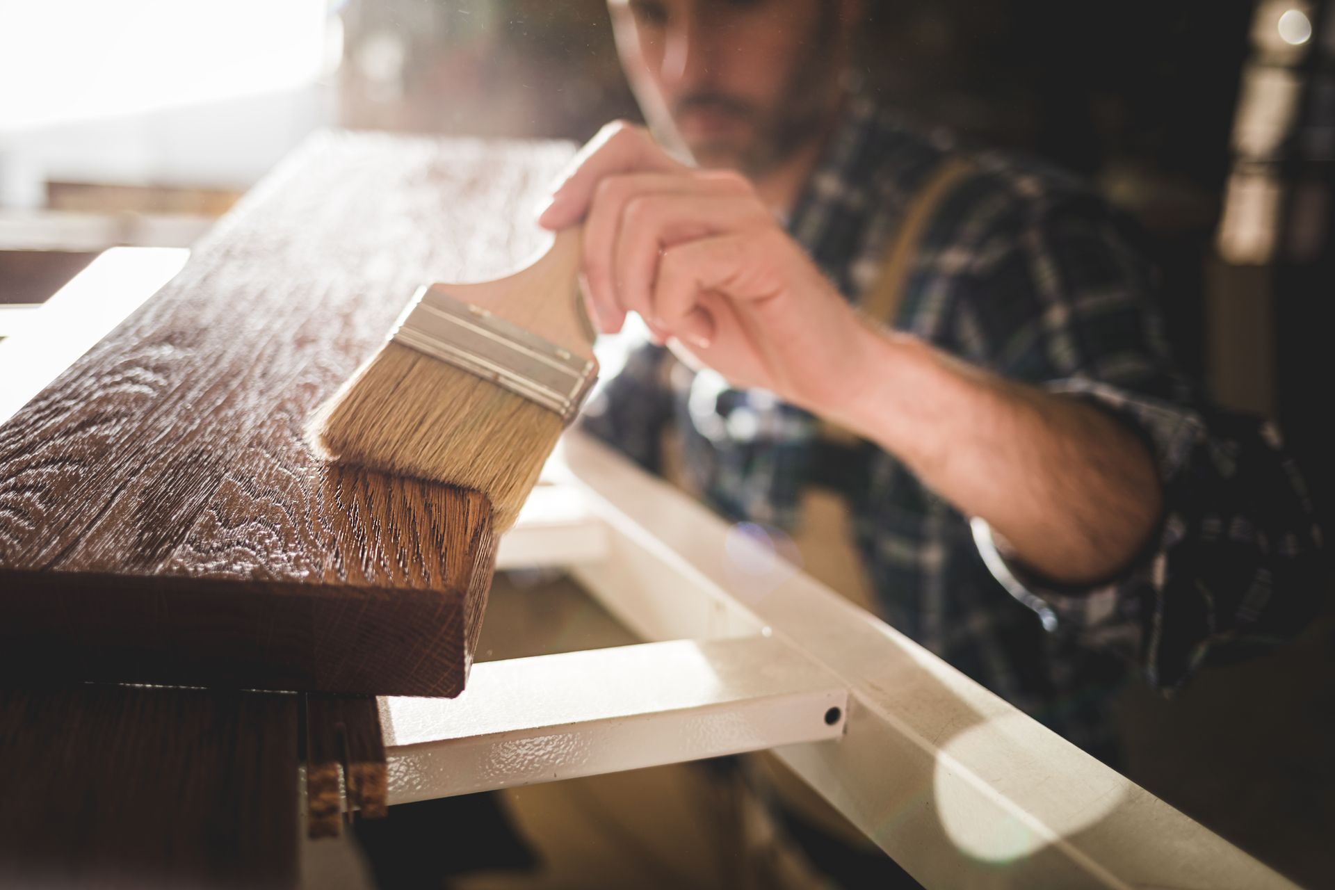 A man is painting a piece of wood with a brush.