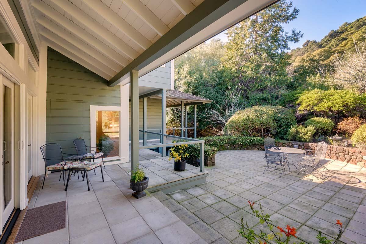 There is a patio with a table and chairs on it.