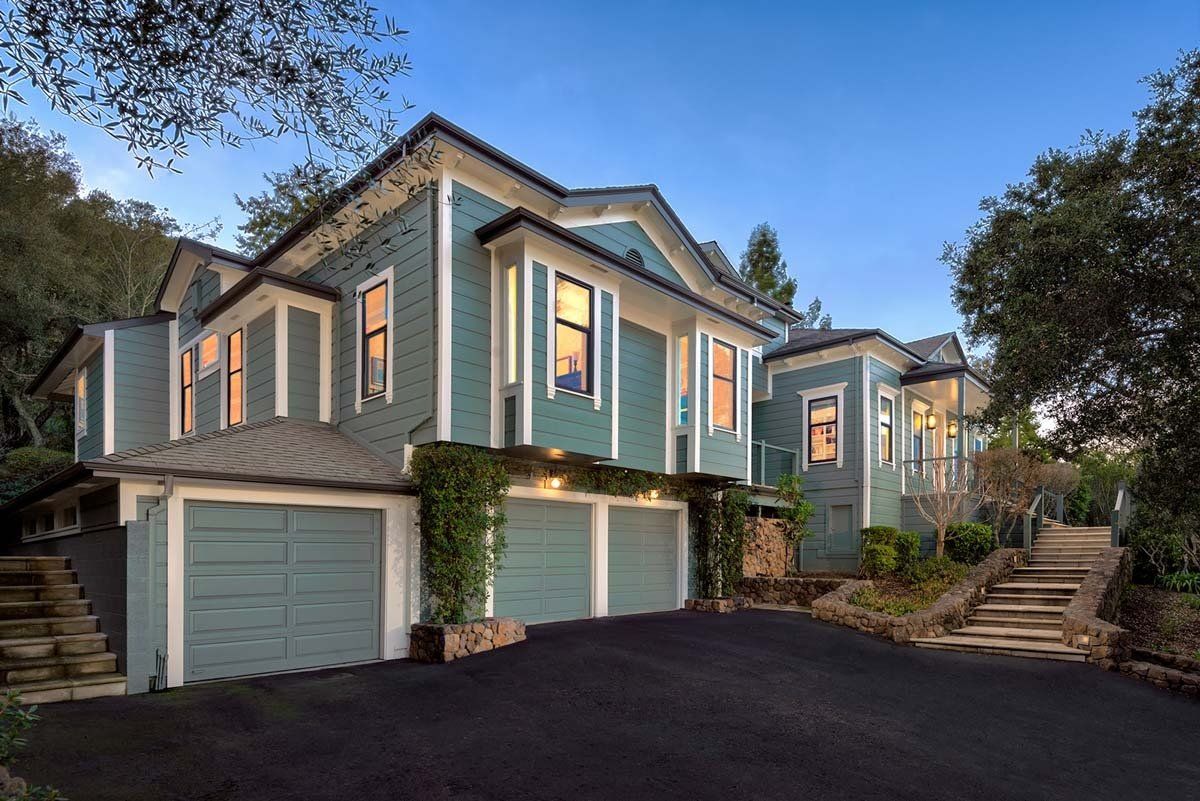 A large house with two garages and stairs leading up to it.