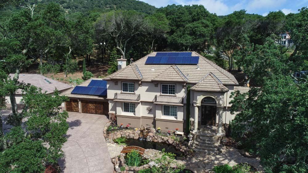 An aerial view of a house with solar panels on the roof