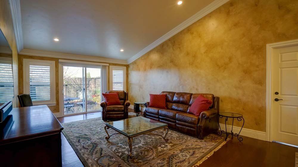 A living room with a couch , chairs , and a coffee table.