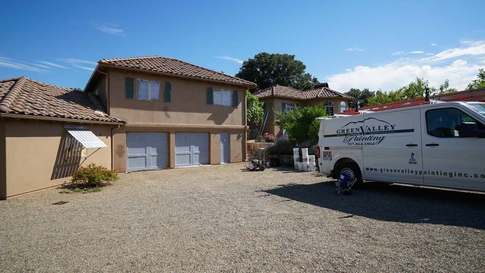 A white van is parked in front of a house