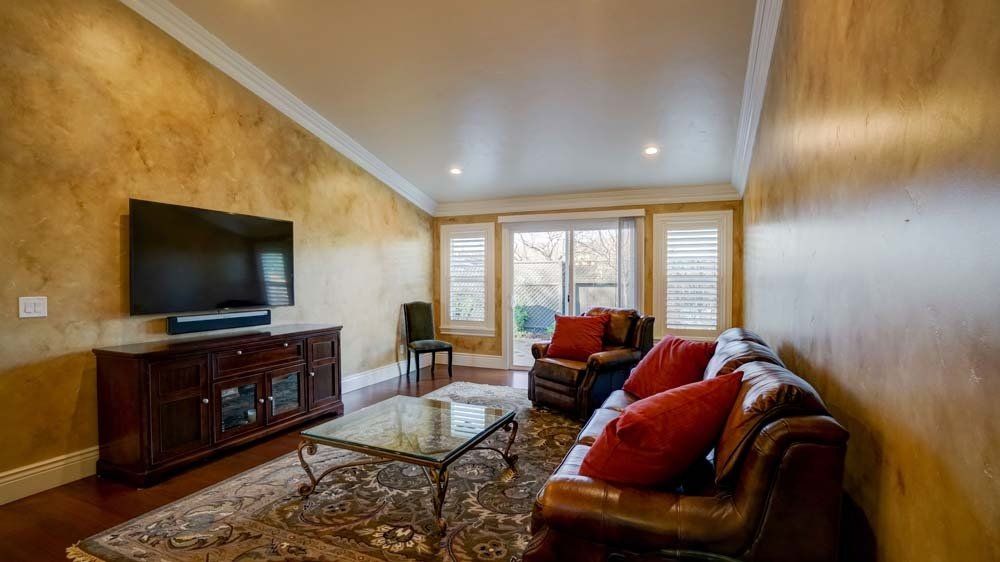 A living room with a couch , chair , coffee table and television.