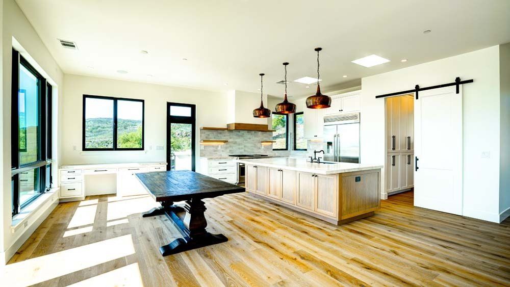 There is a table in the middle of the room in the kitchen.
