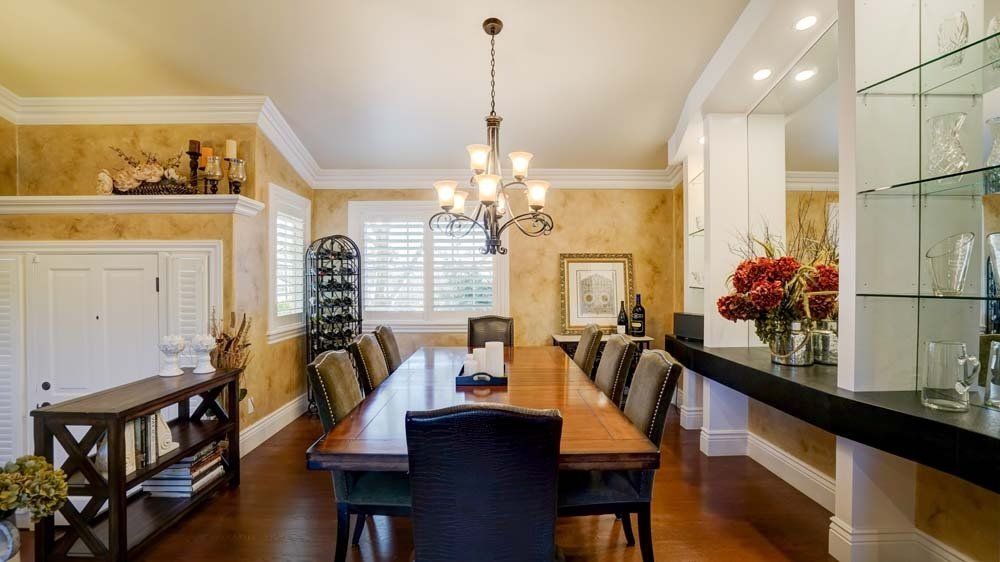 A dining room with a long wooden table and chairs