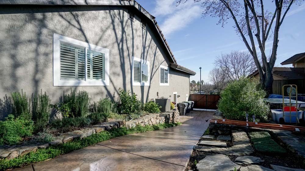 A concrete walkway leading to a house with a lot of windows