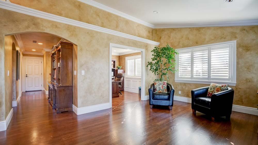 A living room with hardwood floors and two chairs.