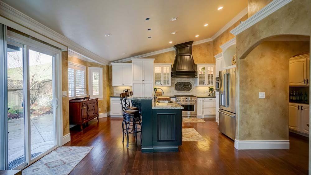 A kitchen with a large island and sliding glass doors.