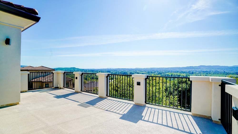 There is a balcony with a view of the mountains and trees.
