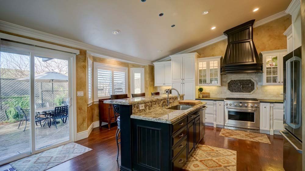A kitchen with stainless steel appliances , granite counter tops , and a large island.