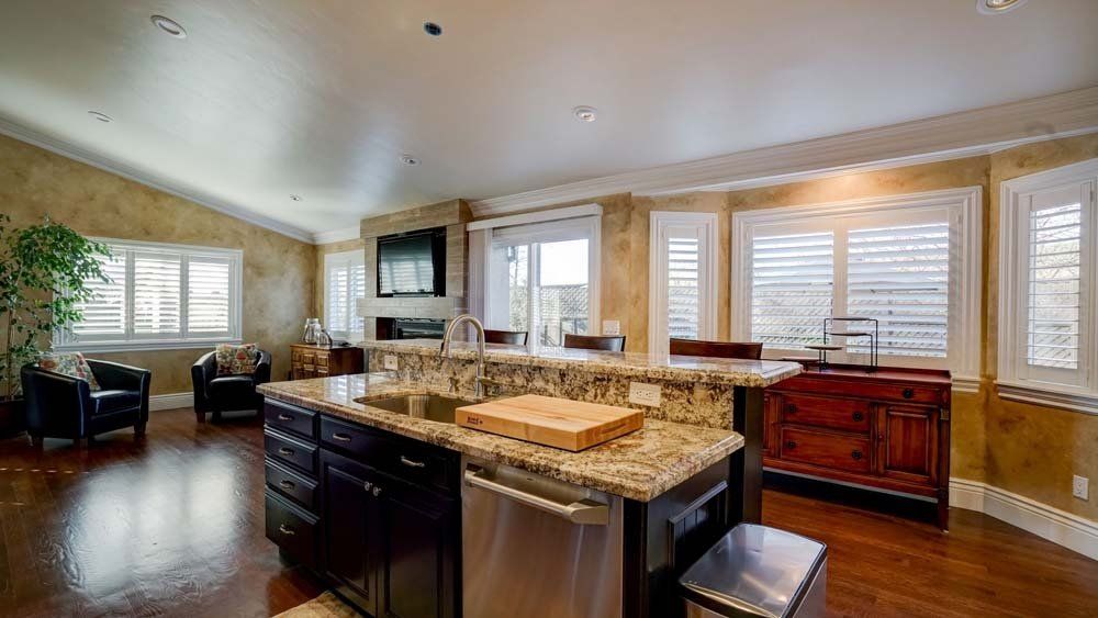 A kitchen with granite counter tops , stainless steel appliances , and a large island.