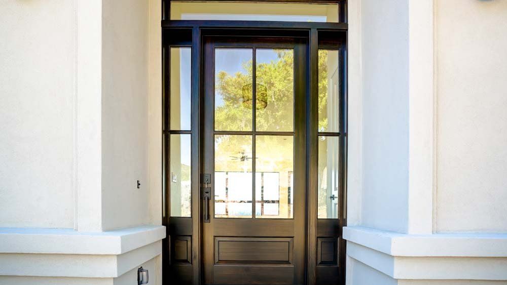 A black door with a lot of windows on a white building.