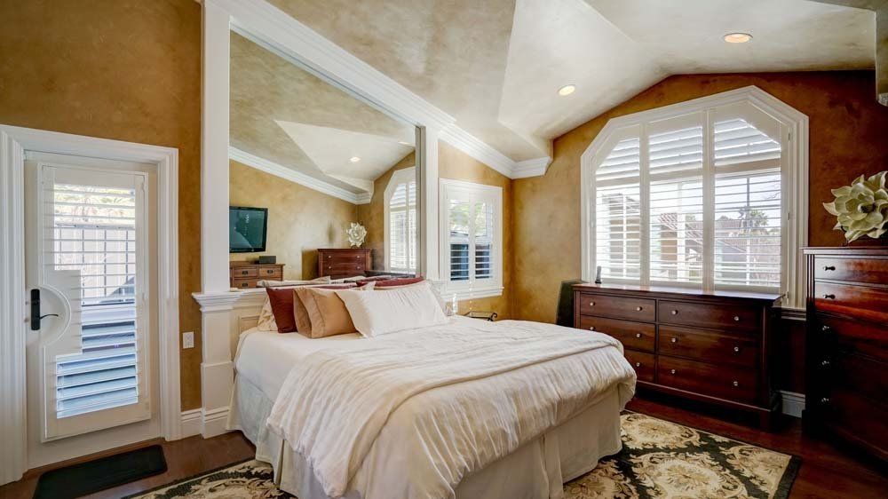 A bedroom with a large bed and a dresser