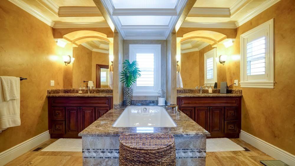 A bathroom with two sinks and a large tub.