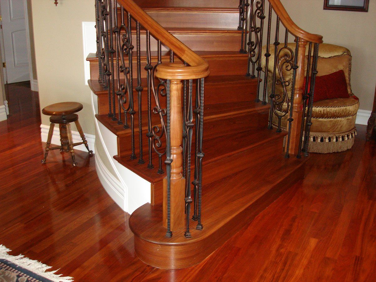 A wooden staircase with a wrought iron railing in a living room