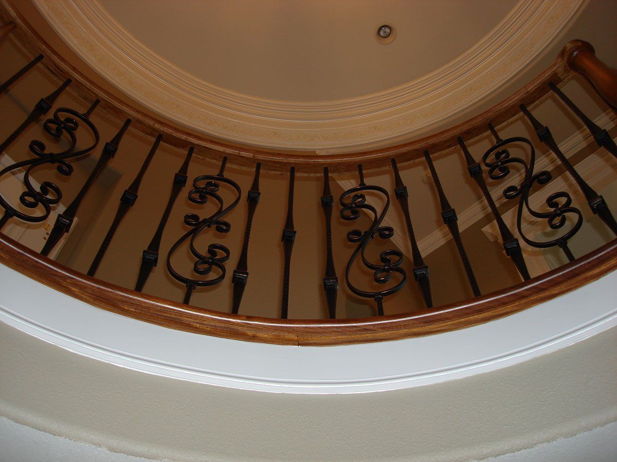 A close up of a wrought iron railing on a curved staircase