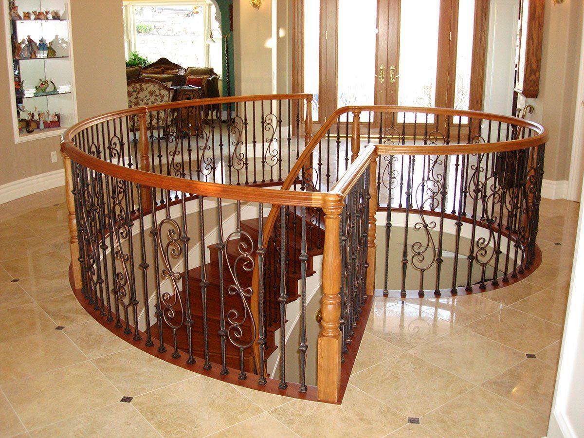 A spiral staircase in a house with a wrought iron railing