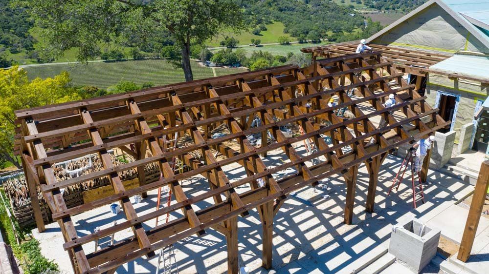 An aerial view of a wooden pergola being built on top of a patio.