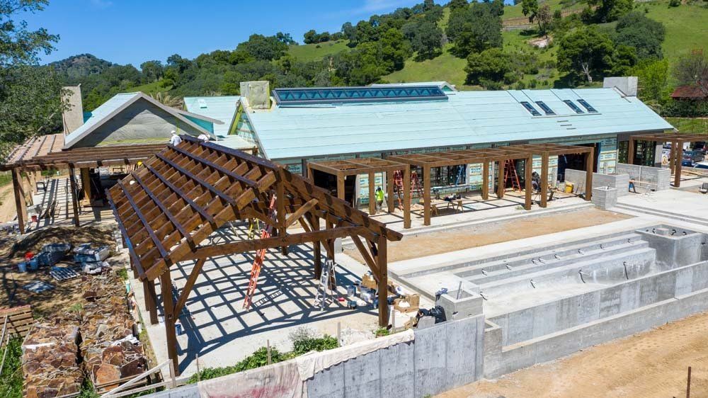 An aerial view of a house under construction with a swimming pool.