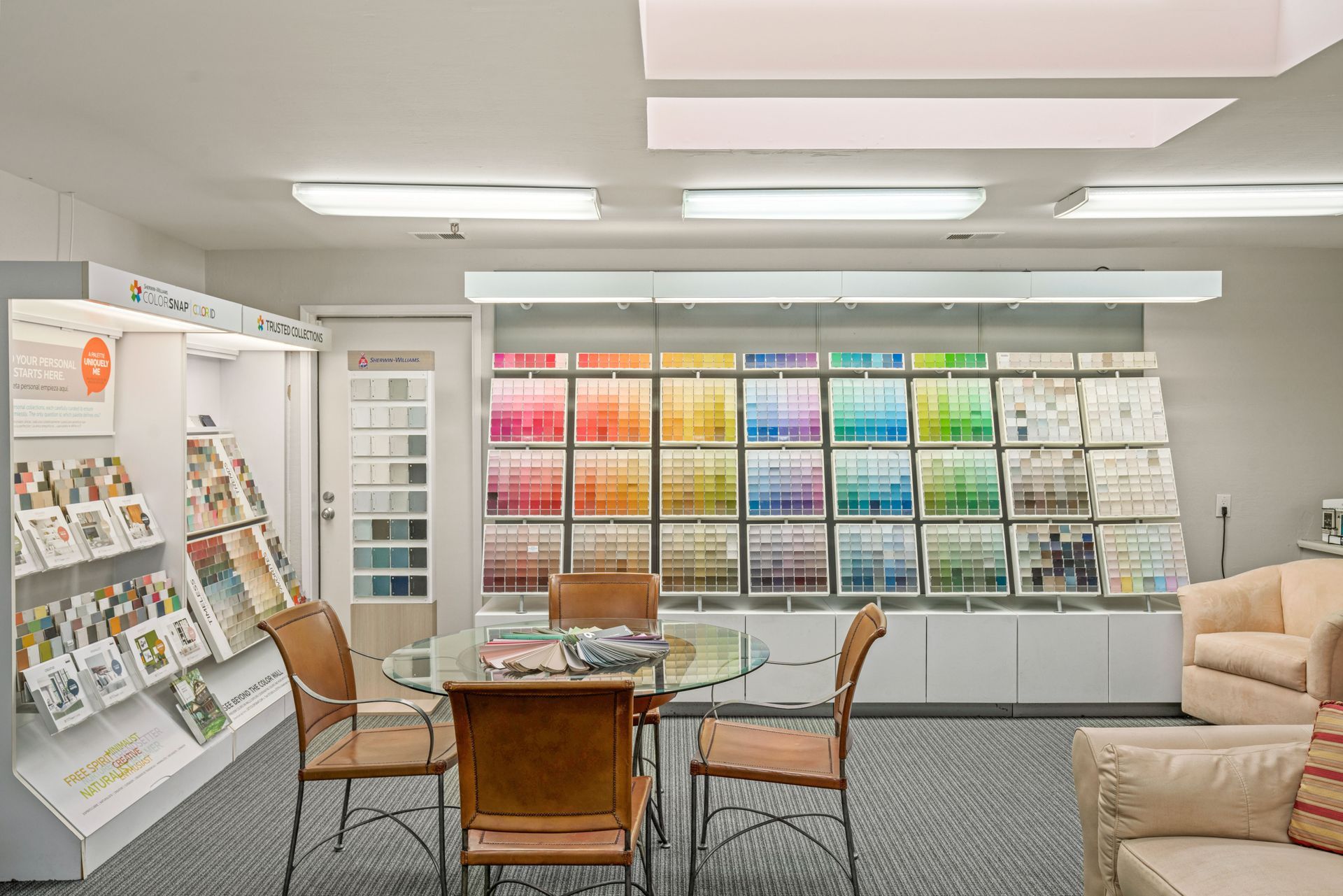 There are two chairs and a table in the lobby of a building.