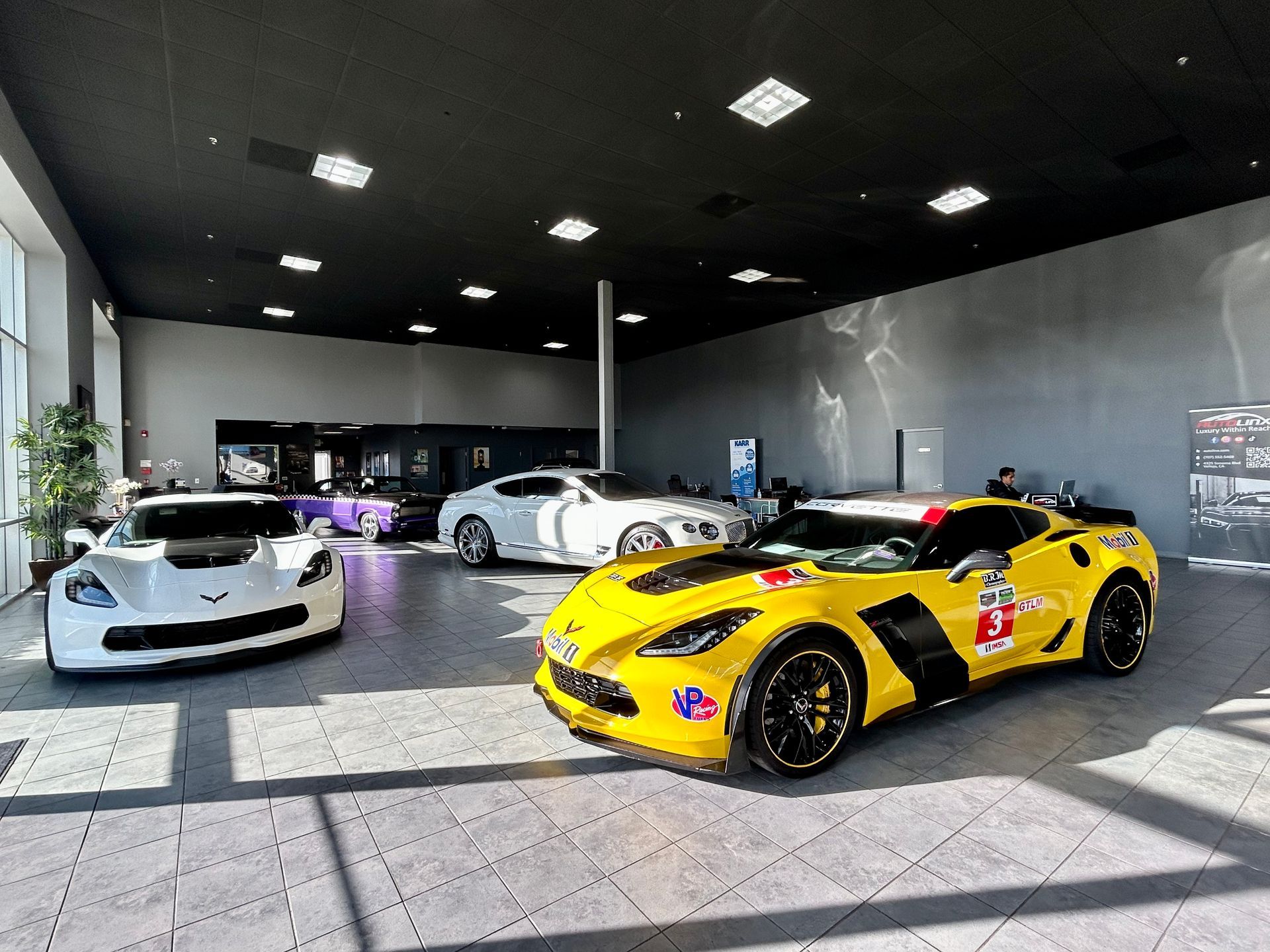 Three sports cars are parked in a showroom.