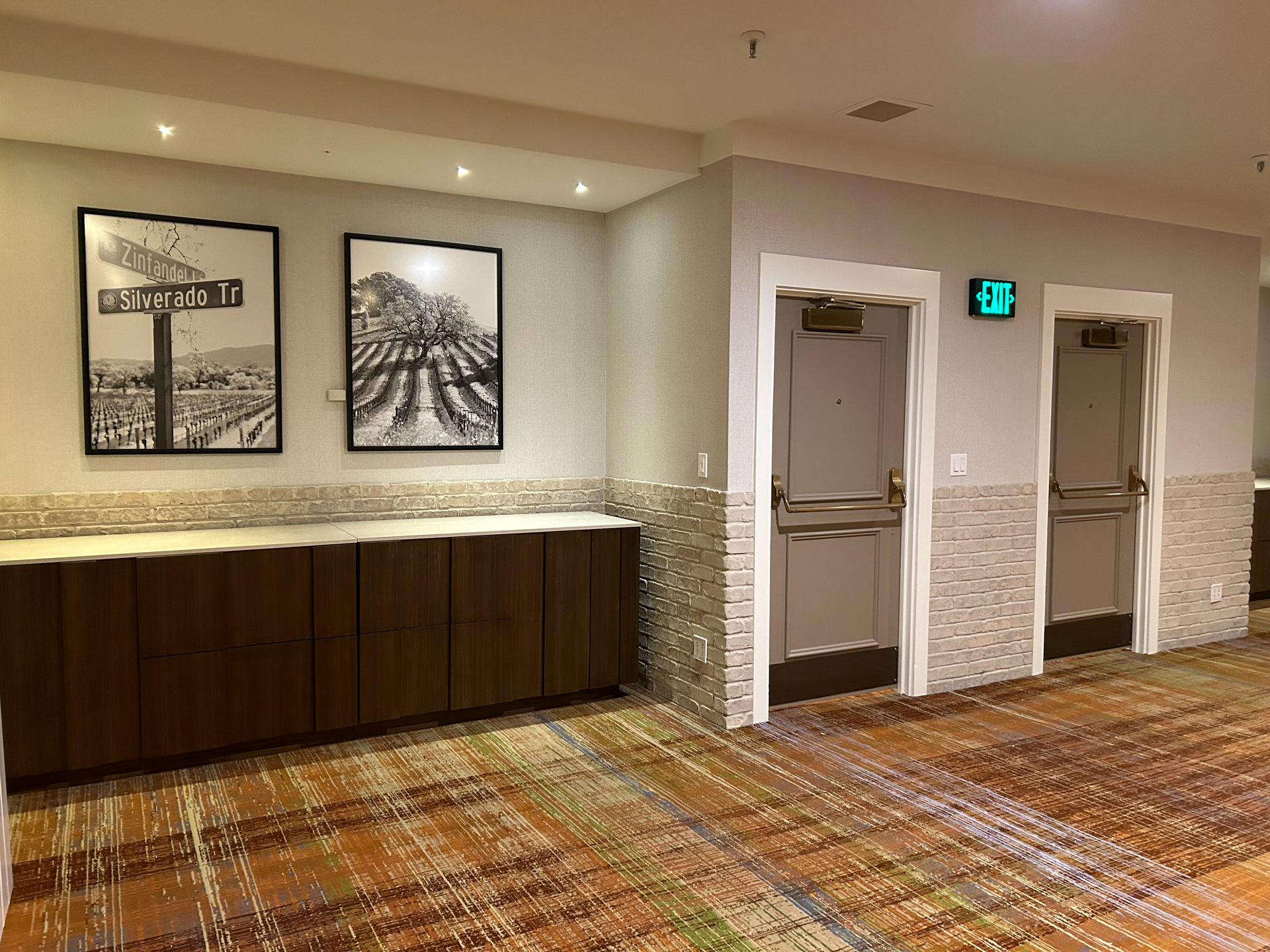 A hallway with a carpeted floor and a few doors.