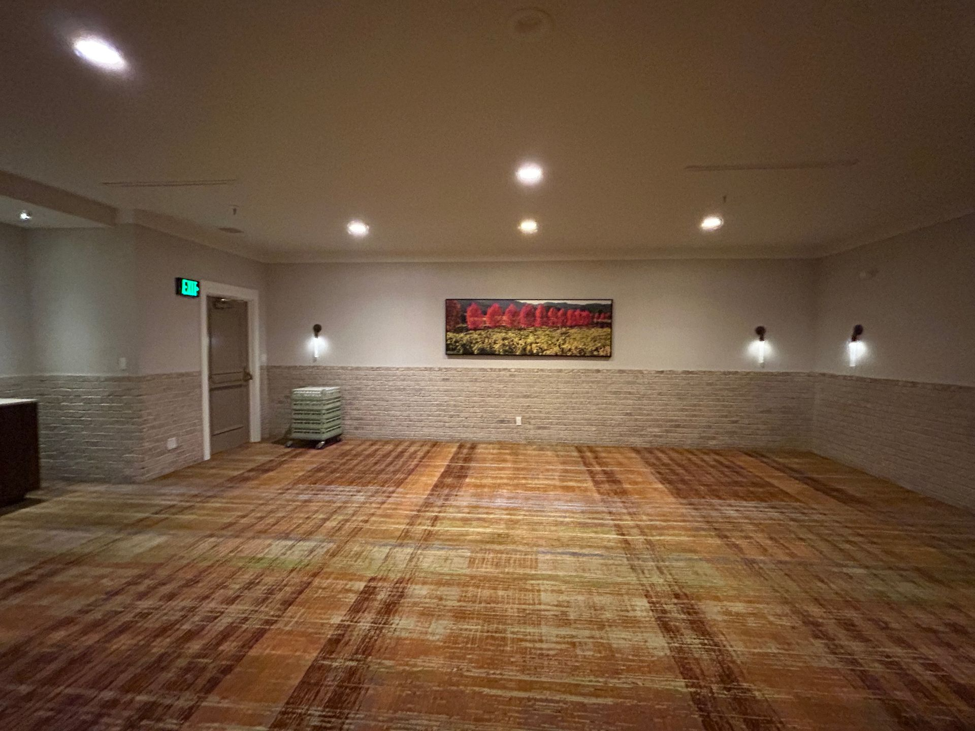 A large empty room with a painting on the wall.