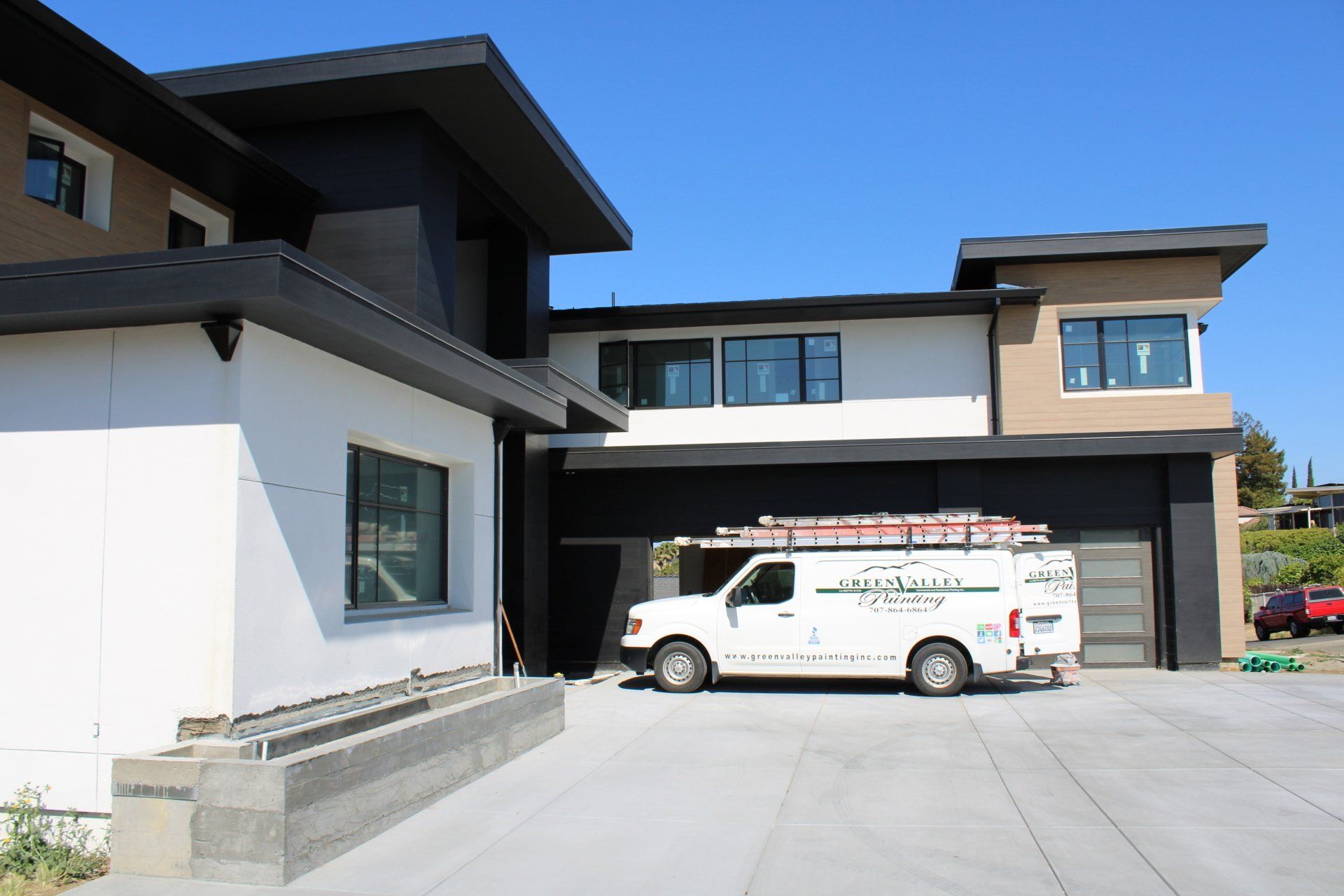 A white van is parked in front of a large house
