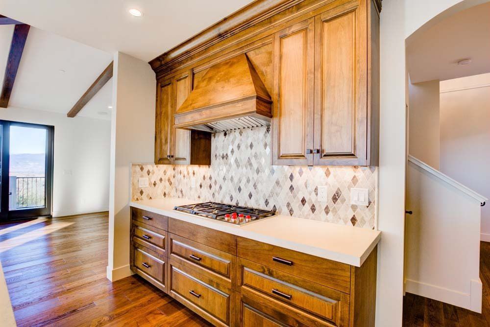 A kitchen with wooden cabinets and a stove top oven.