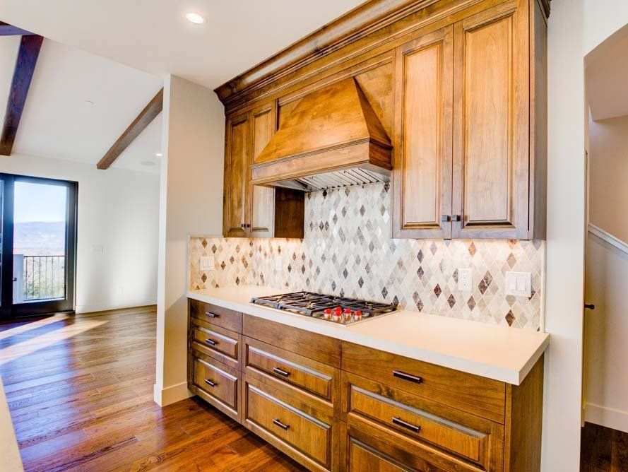 A kitchen with wooden cabinets and a stove top oven.