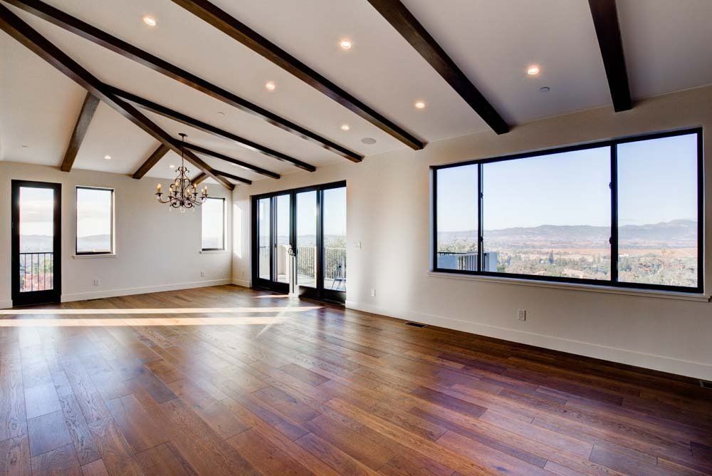 An empty room with hardwood floors and lots of windows