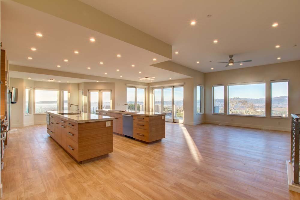 A large empty room with hardwood floors and a large island in the middle.