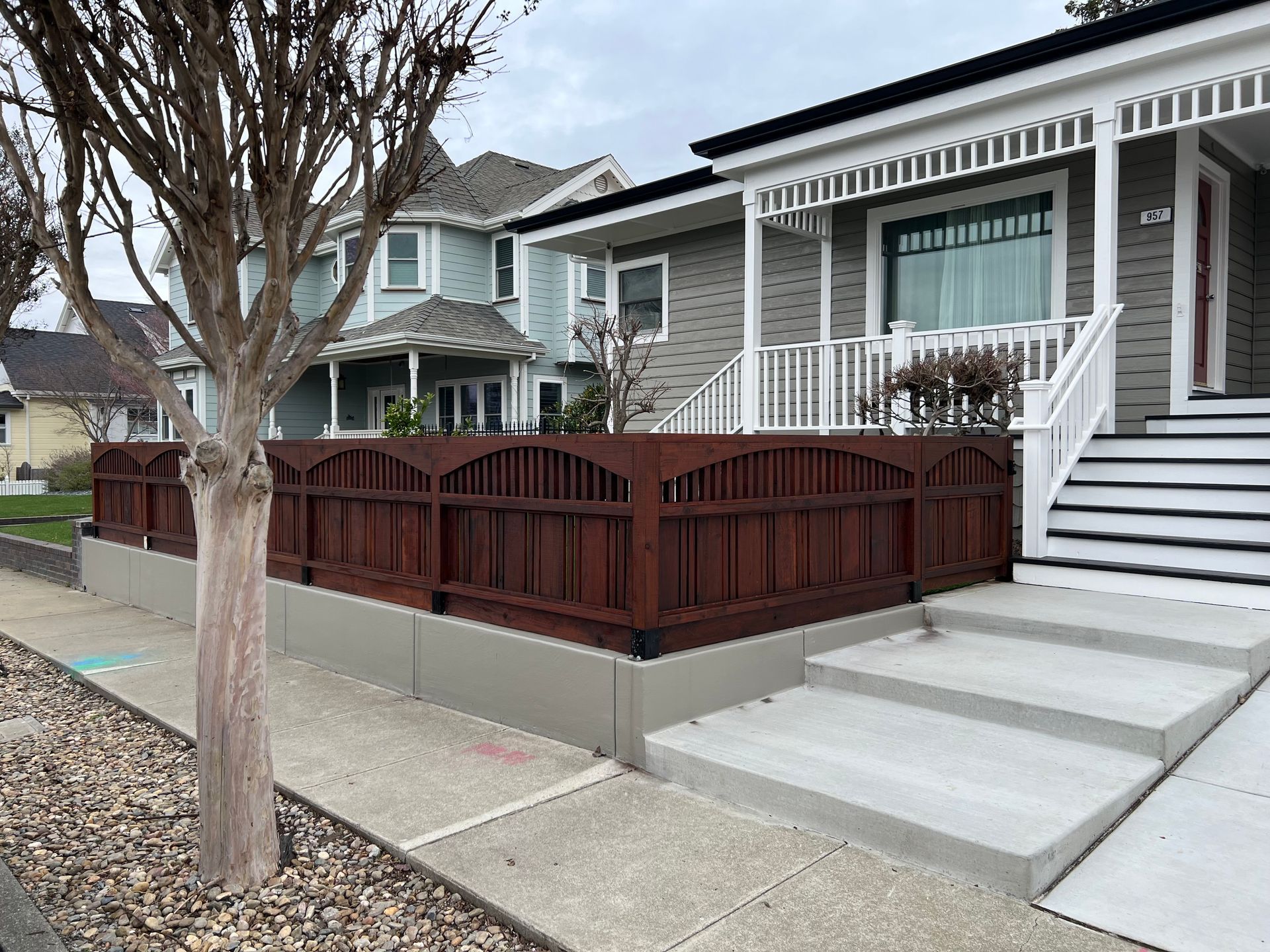A house with a wooden fence and stairs in front of it.