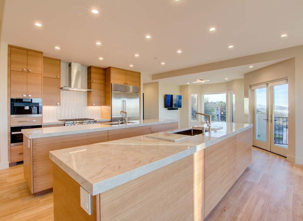 A kitchen with a large island and stainless steel appliances