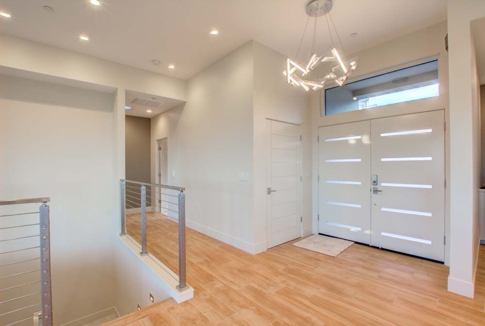 A hallway with wooden floors and a white door in a house.