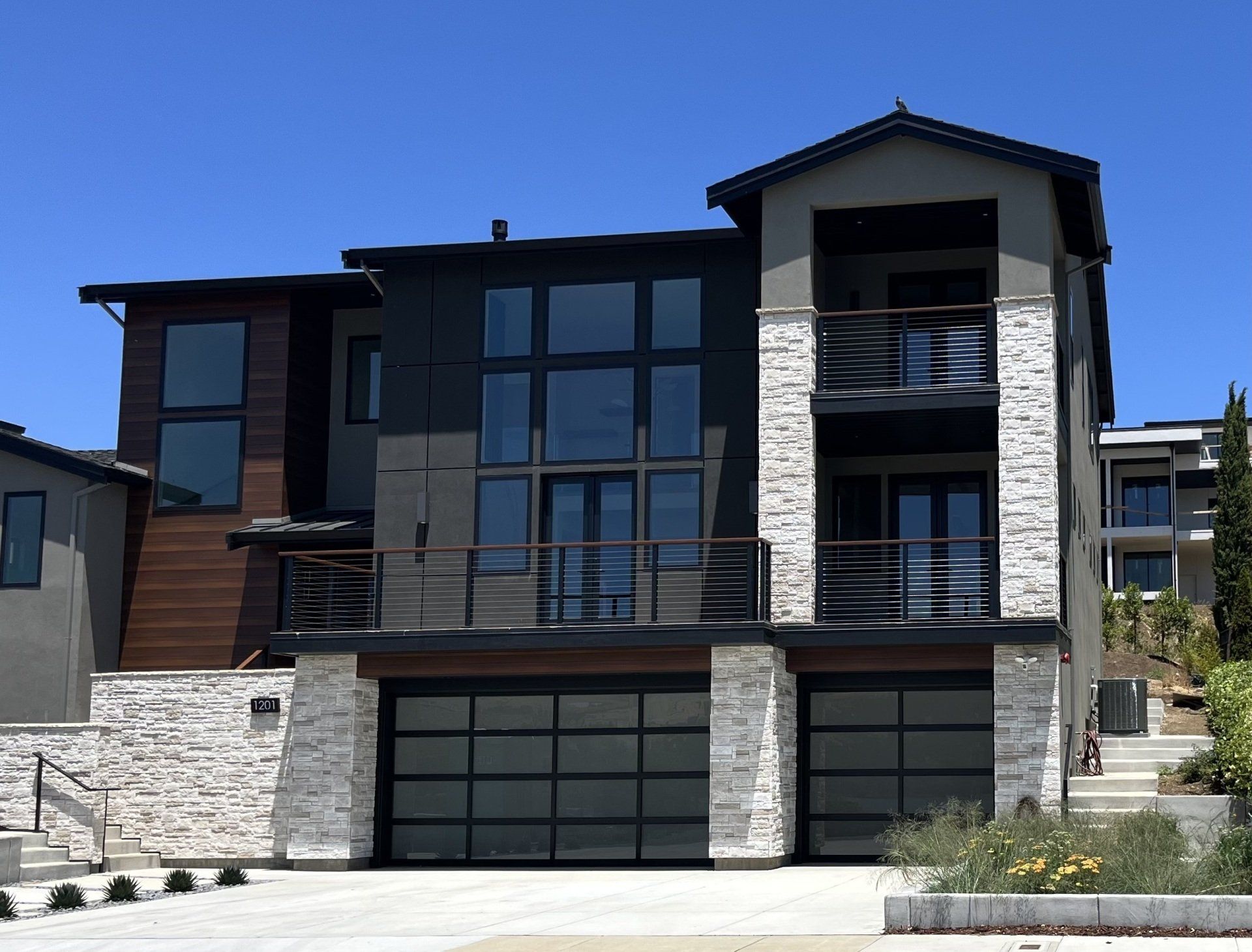 A large house with two garage doors and a balcony