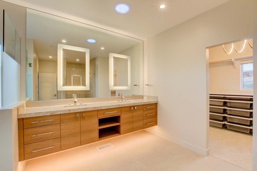 A bathroom with two sinks and a large mirror