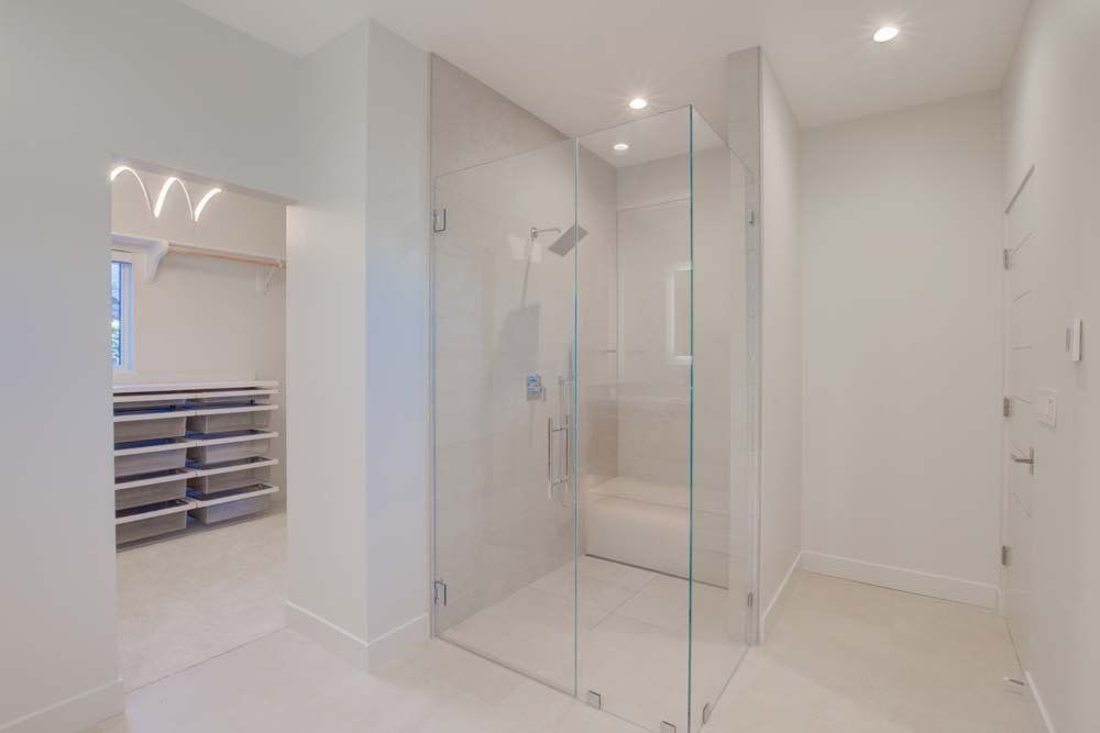 A bathroom with a walk in shower and a walk in closet.