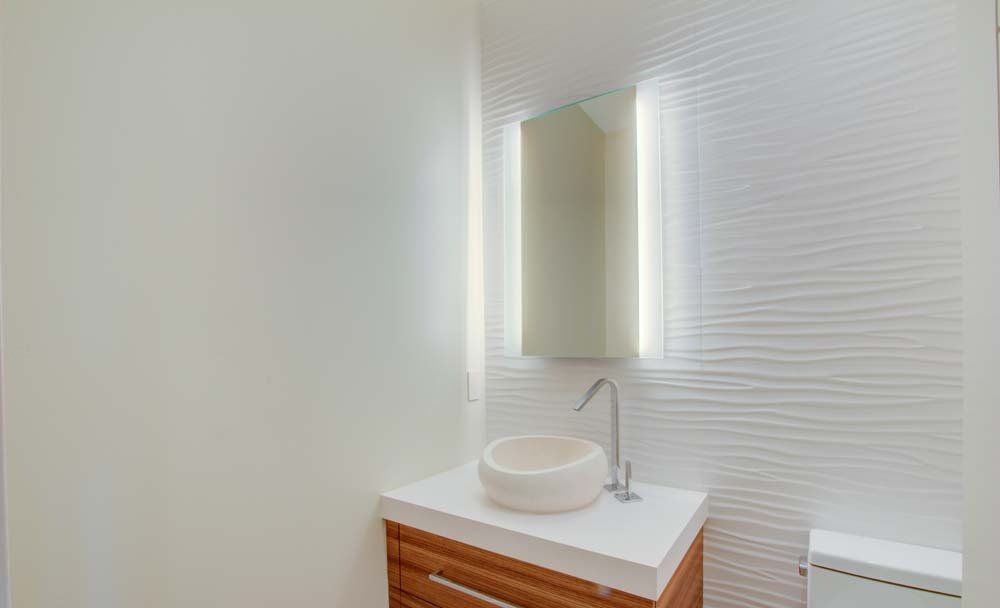 A bathroom with a sink , mirror and toilet.