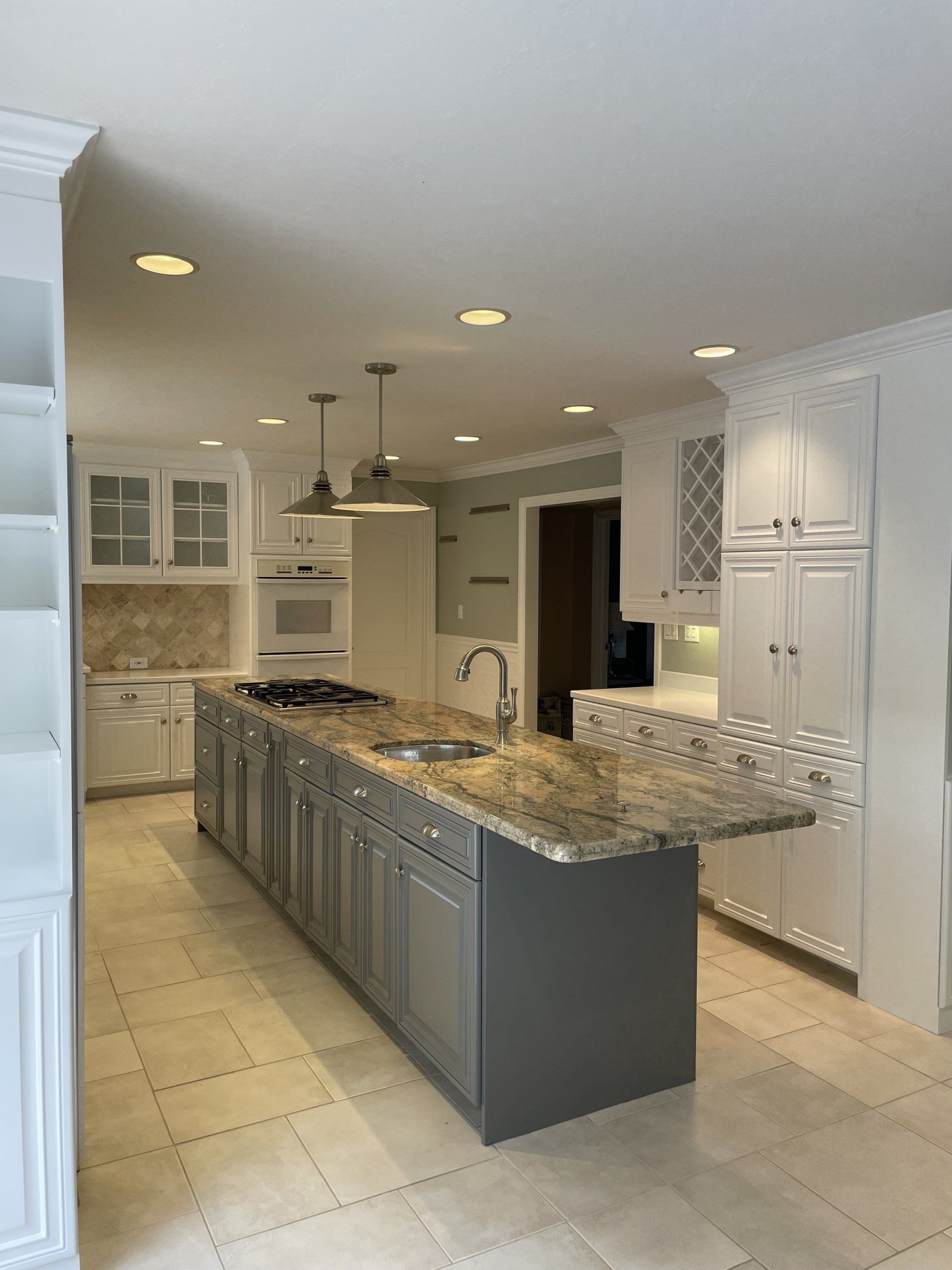 A kitchen with a large island and granite counter tops