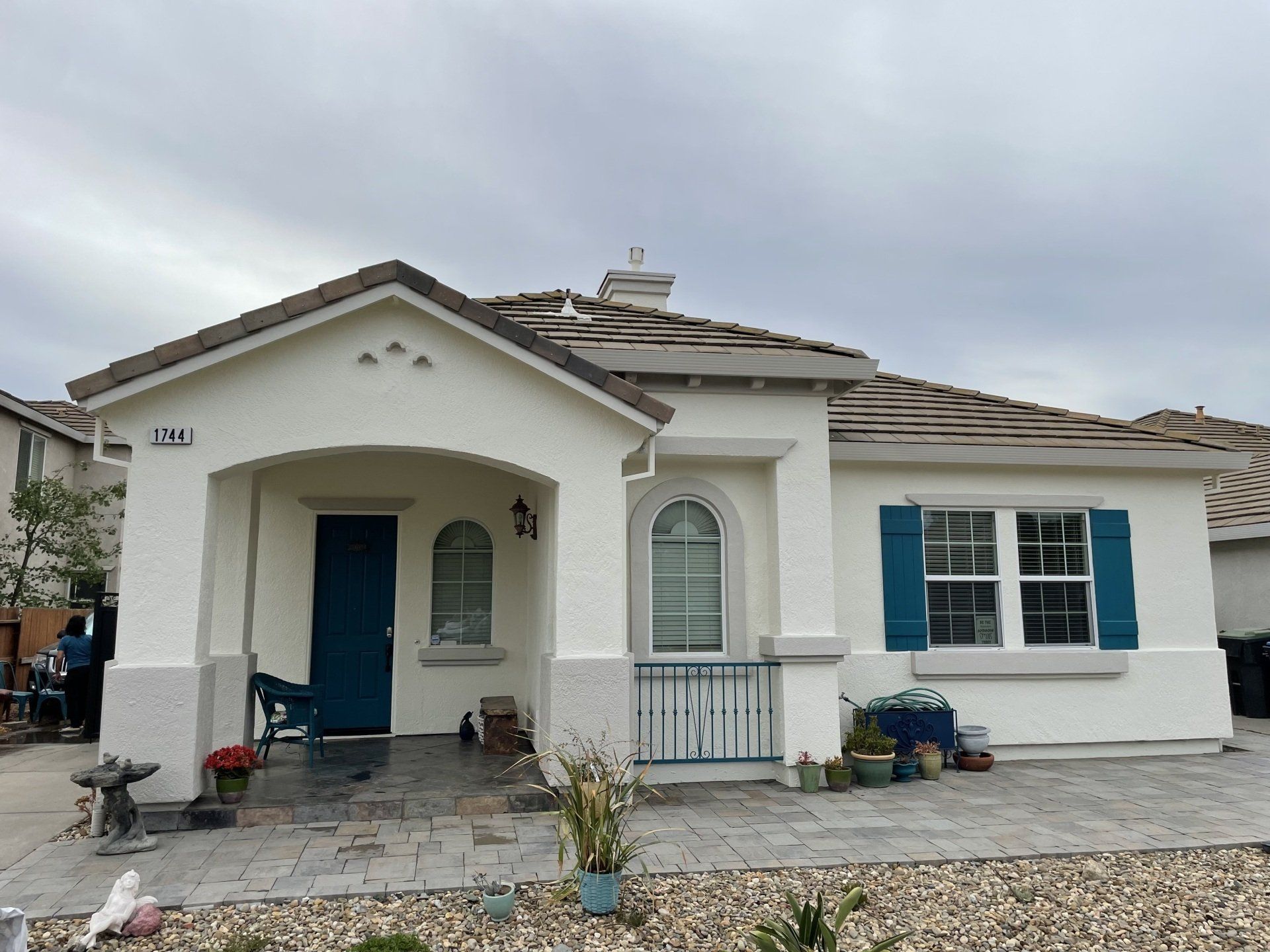A white house with blue shutters and a blue door